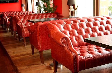 Refurbished restaurant furniture reupholstered with new leather in Los Angeles for commercial furniture restoration.