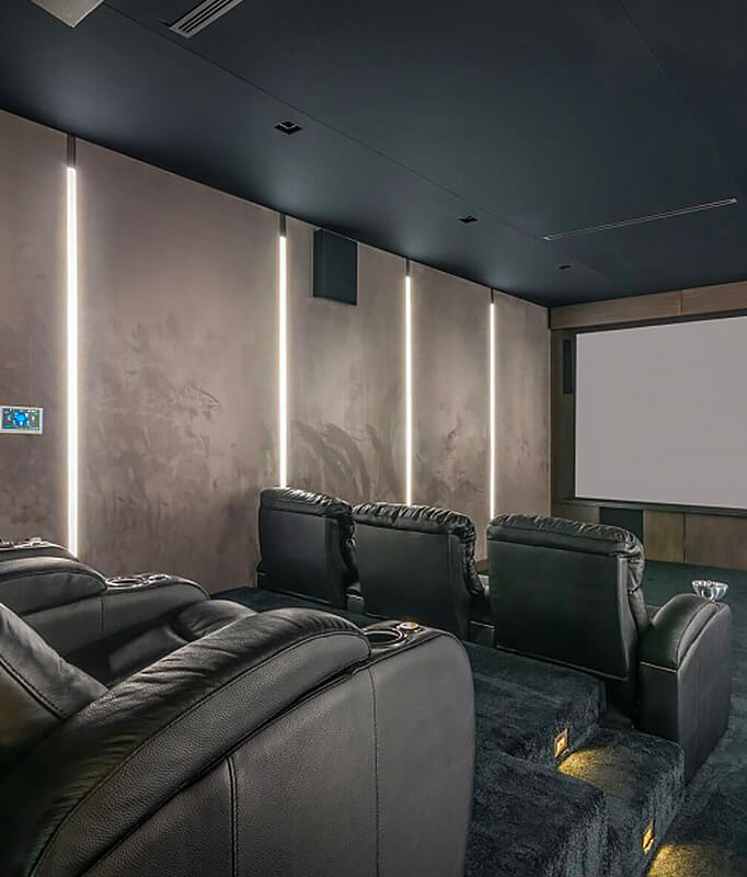 Upholstered wall panels with vertical integrated lighting in a modern home theater seating area