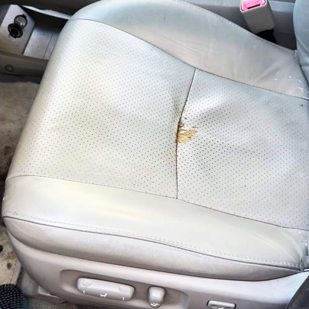 Damaged light gray car leather seat cover before repair