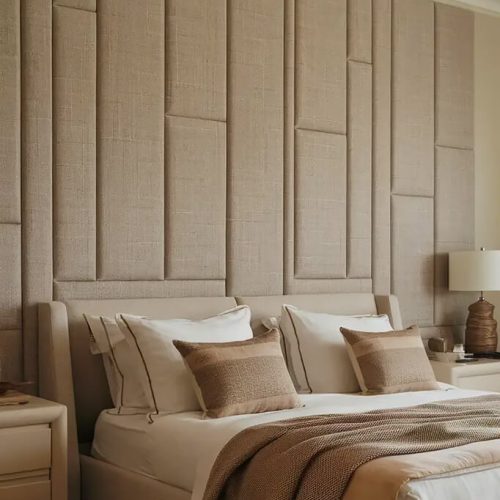 Fabric upholstered wall panels behind a bed in a modern bedroom interior